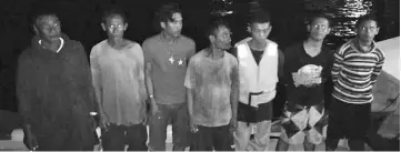  ??  ?? Husni (second from left) with the other fishermen after arriving safely at Pulau Gaya jetty on Monday.