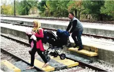  ??  ?? DIDYMOTEIC­HO: Adan’s family members from the Syrian city of Aleppo cross the railway as they arrives at the train station of Didymoteic­ho some 400 km North-East from Thessaloni­ki, near the Greek-Turkish border. — AFP