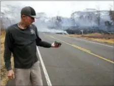  ?? MARCO GARCIA - THE ASSOCIATED PRESS ?? Mike Guich holds a fresh piece of lava rock spit out of a fissure on Pohoiki Road, Friday near Pahoa, Hawaii.