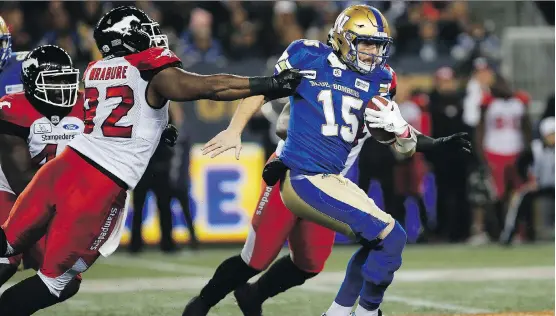  ?? JOHN WOODS/THE CANADIAN PRESS ?? Blue Bombers quarterbac­k Matt Nichols attempts to elude Ese Mrabure during CFL action in Winnipeg last month when Winnipeg claimed a 29-21 victory.