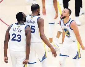  ?? AFP ?? Stephen Curry (30) y Draymond Green (23) festejan con Kevin Durant luego de que anotara un triple decisivo ante los Cavaliers.