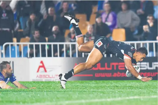  ?? Picture / Photosport ?? Warriors wing Ken Maumalo scores an amazing individual try last night at Mt Smart Stadium in Auckland as despairing Bulldogs half Josh Hodgkinson looks on.