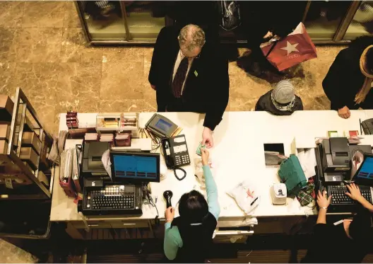  ?? CHRIS HONDROS/GETTY 2009 ?? A shopper pays with a credit card at a Macy’s store in New York City. The average rate on a retail credit card is 26.72%, while a general credit card is around 22.66%.