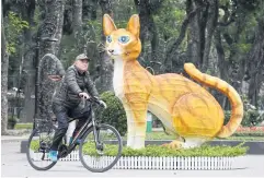  ?? ?? PURR-FECT CHOICE: A man rides past a cat statue at Thong Nhat Park in Hanoi on Jan 16, ahead of the lunar new year.