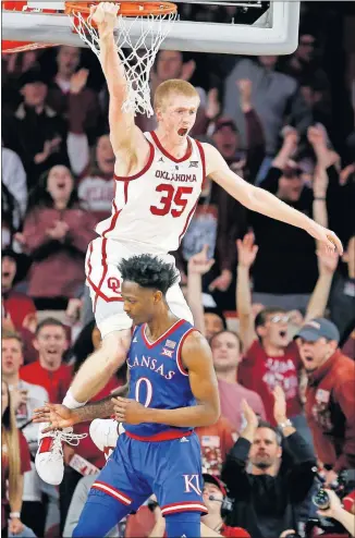  ?? [SARAH PHIPPS/THE OKLAHOMAN] ?? Oklahoma forward Brady Manek reacts after a dunk in front of Kansas's Marcus Garrett during Tuesday night's Big 12 game at Lloyd Noble Center in Norman.