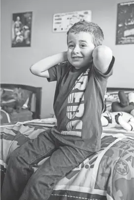  ?? AL LASSEN / FOR THE MILWAUKEE JOURNAL SENTINEL ?? Micah Wade, 7, covers his ears to avoid hearing the TV in his room.