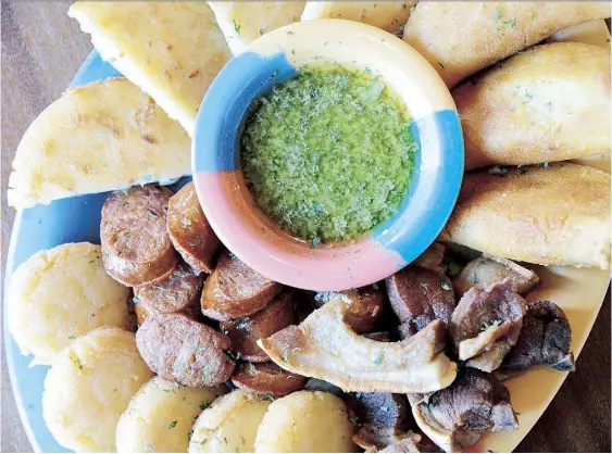  ??  ?? A LA izquierda, plato de antojitos colombiano­s, que cuenta con tostadas de plátano con ahogado, chicharron­es con arepa, arepas de queso, chorizos y empanadas colombiana­s.