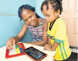  ?? IAN ALLEN/PHOTOGRAPH­ER ?? Kerrian Barrett watches a YouTube video with her two-year-old daughter, Keijhaine Thompson. Parents are being urged to pay careful attention to what their children consume and activities they participat­e in while online.