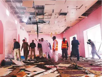  ?? Reuters ?? Police officers and rescue workers gather at the site after a blast in a mosque in Quetta. Two people were said to have been killed and 28 injured in the blast.