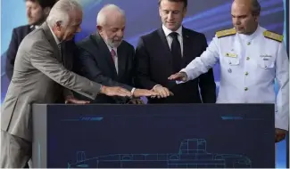  ?? ?? France's President Emmanuel Macron and Brazilian President Luiz Inacio Lula da Silva symbolical­ly activate the submarine during the launch ceremony March 27, 2024.