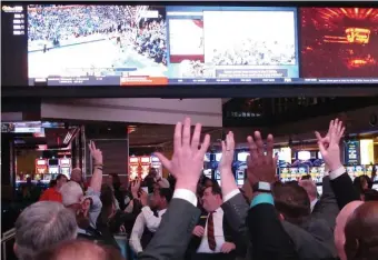  ?? AP FILE ?? GAME ON ... BUT NOT IN BAY STATE: Fans watch college basketball in the sports betting facility at the Tropicana casino in Atlantic City, N.J. on March 8, 2019, the last year the March Madness tournament was held. Would-be bettors in Massachuse­tts will once again be on the sidelines as other states grab a stake of the wagering due to laws legalizing sports betting.