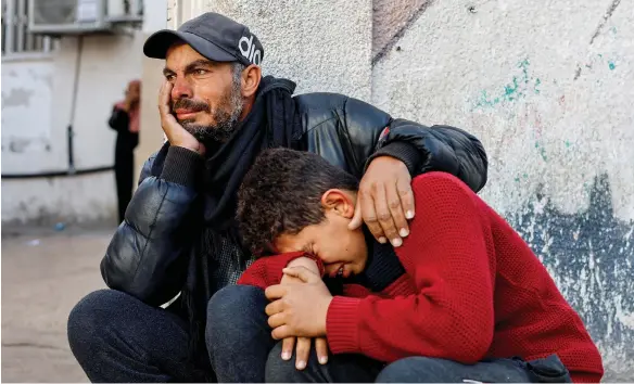  ?? Reuters ?? Palestinia­ns react after seeing the bodies of those killed in Israeli strikes at Abu Yousef Al Najjar hospital, in Rafah, Gaza yesterday