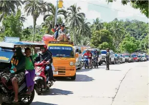  ??  ?? Fleeing in fear: A government troop checking vehicles as residents evacuate Marawi city. — Reuters