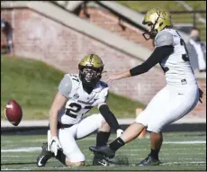  ?? Associated Press ?? DAY —
HISTORIC In this Nov. 28 photo, Vanderbilt’s Sarah Fuller, right, kicks off as Ryan McCord (27) holds to start the second half of a college football game against Missouri in Columbia, Mo. With the kick, Fuller became the first female to play in a Southeaste­rn Conference football game. Fuller was also the first woman to score in an SEC game by kicking an extra point after a touchdown.