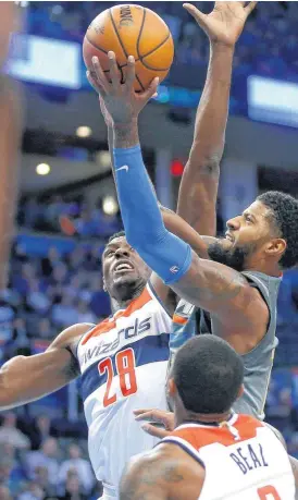  ?? [PHOTO BY BRYAN TERRY, THE OKLAHOMAN] ?? Oklahoma City’s Paul George puts up a shot beside Washington’s Ian Mahinmi during Thursday’s game between the Oklahoma City Thunder and the Washington Wizards at Chesapeake Energy Arena. The Thunder won, 121-112.