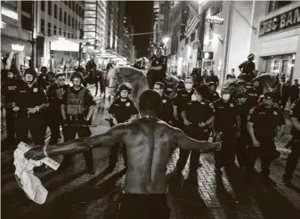  ?? Jon Shapley / Staff photograph­er ?? A man yells at Houston officers at the intersecti­on of Main and McKinney streets in downtown as hundreds of George Floyd protesters blocked roads and hurled objects on May 29.