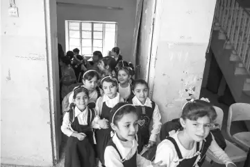  ??  ?? Pupils walk out from their classroom at an elementary school in eastern Mosul, Iraq. — Reuters photo