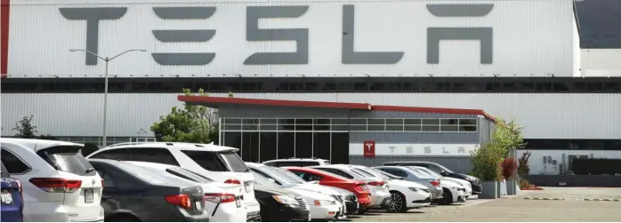  ?? BEN MARGOT, AP FILE ?? Vehicles are parked outside the Tesla plant in Fremont, Calif., on May 12, 2020. California sued Tesla Inc. last week over allegation­s of discrimina­tion and harassment of Black employees at its factory.