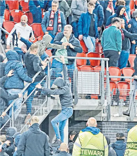  ?? ?? Terror in the stands: AZ Alkmaar fans storm the away end (above); riot police outside the stadium (left); Declan Rice confronts thugs (right) as horror scenes unfold