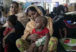  ?? PAULA BRONSTEIN, GETTY IMAGES ?? Rohingya wait for treatment on Sunday in Amtola, Cox’s Bazar, Bangladesh. More than 430,000 Rohingya refugees have fled into Bangladesh since late August.