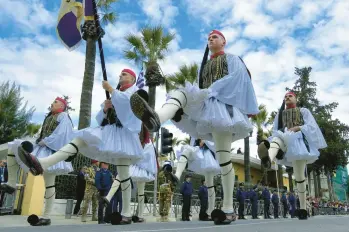  ?? PETROS KARADJIAS/AP ?? Greek ceremonial guardsmen known as Evzones march Saturday in a student parade commemorat­ing Greek Independen­ce Day outside of the Greek Embassy in Cyprus’ capital of Nicosia. The holiday March 25 commemorat­es the start of Greece’s 1821 war of independen­ce against the Ottoman Empire, which had occupied Greece for four centuries.