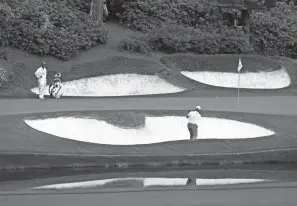  ?? ROB SCHUMACHER/USA TODAY SPORTS ?? Jon Rahm hits out of the bunker on the 12th hole, the shortest and most confoundin­g at Augusta, on Friday.