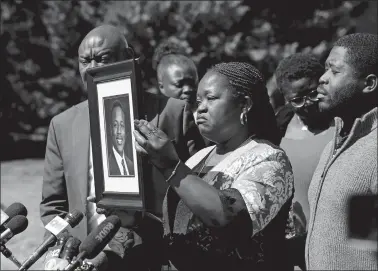  ?? DANIEL SANGJIB MIN/RICHMOND TIMES-DISPATCH VIA AP ?? Caroline Ouko, mother of Irvo Otieno, holds a portrait of her son on Thursday with attorney Ben Crump, left, and her older son, Leon Ochieng at the Dinwiddie Courthouse in Dinwiddie, Va. She said Otieno, who died in a state mental hospital March 6, was “brilliant and creative and bright.”