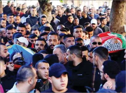  ?? (AFP) ?? Mourners and fighters carry the bodies of Jawad Farid Bawaqna (right) and Adham Mohammed Bassem Jabareen, during their funeral in the occupied-West Bank city of Jenin, on Thursday.