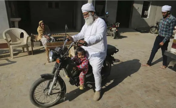  ?? ALTAF QADRI/THE ASSOCIATED PRESS ?? Gurdev Singh takes his daughter, Gurjeet Kaur, on a joyride in the compound of their house in Ellenabad, India. Singh’s wife, Manjeet Kaur, gave birth to Gurjeet at age 58.