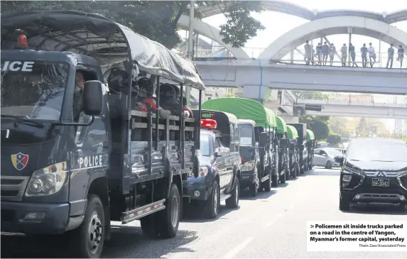  ?? Thein Zaw/Associated Press ?? Policemen sit inside trucks parked on a road in the centre of Yangon, Myanmar’s former capital, yesterday