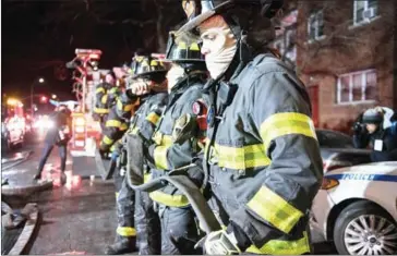  ?? DAVID DEE DELGADO/THE NEW YORK TIMES ?? Firefighte­rs at the scene of a deadly fire on Thursday night at a five-storey apartment building in the Belmont section of the Bronx.