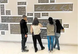  ?? KATE BRUMBACK/AP ?? Visitors to the National Center for Civil and Human Rights in Atlanta view a new art installati­on featuring the words of Martin Luther King Jr. in his own handwritin­g.