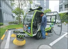  ?? YIN LIQIN / CHINA NEWS SERVICE ?? Left: An engineer adjusts the software settings of a driverless sweeper truck at the Tus-Caohejing Science Park in Shanghai in April.