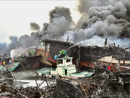  ?? — Reuters ?? Up in smoke: Firefighte­rs trying to bring the blaze under control at Benoa port in Denpasar that laid waste to dozens of boats.