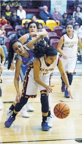  ?? LUIS SÁNCHEZ SATURNO/THE NEW MEXICAN ?? Santa Fe Indian School’s Leanna Lewis, front, scrambles for the ball against Socorro on Friday in the first round of the Class 4A State Tournament in the Pueblo Pavilion. The Lady Braves won, 61-56, and move on to face Moriarty in the Pit.