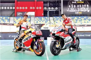  ?? -Gambar Bernama ?? PELUMBA MotoGP Ducati Team Jorge Lorenzo (kanan) bersama Pelumba MotoGP Repsol Honda Team Marc Marquez bergambar bersama jentera masing-masing selepas sesi perlawanan persahabat­an bersama bekas pemain badminton negara Rashid Sidek dan Yap Kim Hok...