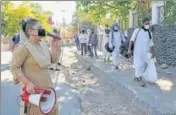  ?? NITIN KANOTRA/HT ?? A woman police personnel asks passengers to maintain social distance as they walk towards the railway station to board a train to New Delhi, in Jammu on Friday.