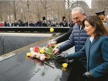  ?? JOHN MINCHILLO/AP ?? Sen. Chuck Schumer and New York Gov. Kathy Hochul place flowers Sunday for the 1993 bombing victims.