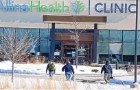  ?? DAVID JOLES/STAR TRIBUNE ?? Law enforcemen­t personnel walk toward the Allina Health clinic Tuesday in Buffalo, Minn. Authoritie­s say multiple people were shot and that someone was taken into custody afterward.