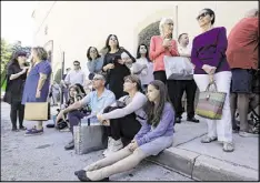  ?? LYNNE SLADKY / ASSOCIATED PRESS ?? Shoppers sit on the pavement after being evacuated from the Shops at Merrick Park after a shooting Saturday in Coral Gables, Fla. Abeku Wilson, 33, of Miami, killed two managers at Equinox gym on Saturday before fatally shooting himself.