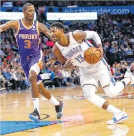  ??  ?? Oklahoma City’s Paul George (13) drives against Phoenix’s Trevor Ariza (3) during Monday’s game.