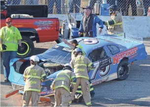  ?? PHOTOS BY DAVE KALLMANN MILWAUKEE JOURNAL SENTINEL ?? Fred Winn walks away from his car after being involved in a crash in the Slinger Speedway season opener April 29. The wreck was a significan­t setback for a the 64-year-old racer from Milwaukee who operates on a small budget.