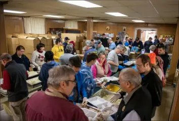  ?? Pittsburgh Post-Gazette photos ?? Volunteers package nearly 3,900 meals on Thursday at Mary’s Holy Assumption Orthodox Church on the South Side as part of the “Get Stuffed with Love” meal distributi­on event.