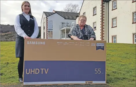  ??  ?? Reception team leader and charity co-ordinator at Auchrannie Resort Kirsty MacQueen hands over the TV set to McKelvie Road resident Veronica Cranwell.