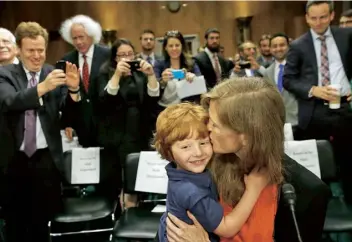  ??  ?? At her confirmati­on hearing to become US ambassador to the UN, with her son, Declan, 2013