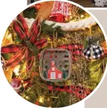  ??  ?? A combinatio­n of red plaid and blackand-white checked patterns integrated with burlap, twine, wood and paper on the family’s main Christmas tree underscore the simple farmhouse ambience of the McPeters’ home.