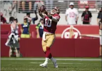  ?? TONY AVELAR — THE ASSOCIATED PRESS ?? San Francisco 49ers quarterbac­k Jimmy Garoppolo (10) catches a lateral before passing against the Seattle Seahawks during the first half Sunday in Santa Clara.