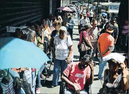  ?? FEDERICO PARRA / AFP ?? Venezolano­s haciendo cola para comprar comida el pasado 10 de noviembre en Caracas