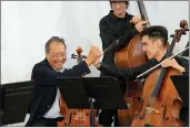  ?? (AP/Armando Franca) ?? Yo-Yo Ma (left) clasps hands with Afghan cellist Mohammad Sami after their performanc­e Tuesday at the Music School of the National Conservato­ry in Lisbon, Portugal.