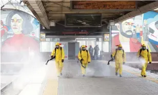  ?? PAVEL GOLOVKIN THE ASSOCIATED PRESS ?? Workers disinfect a platform at the Leningrads­ky railway station in Moscow on Tuesday.